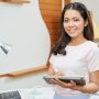 guru perempuan menggunakan AI dalam tablet saat mengajar membawa dampak positif AI dan juga perlu waspada terhadap dampak negatif AI